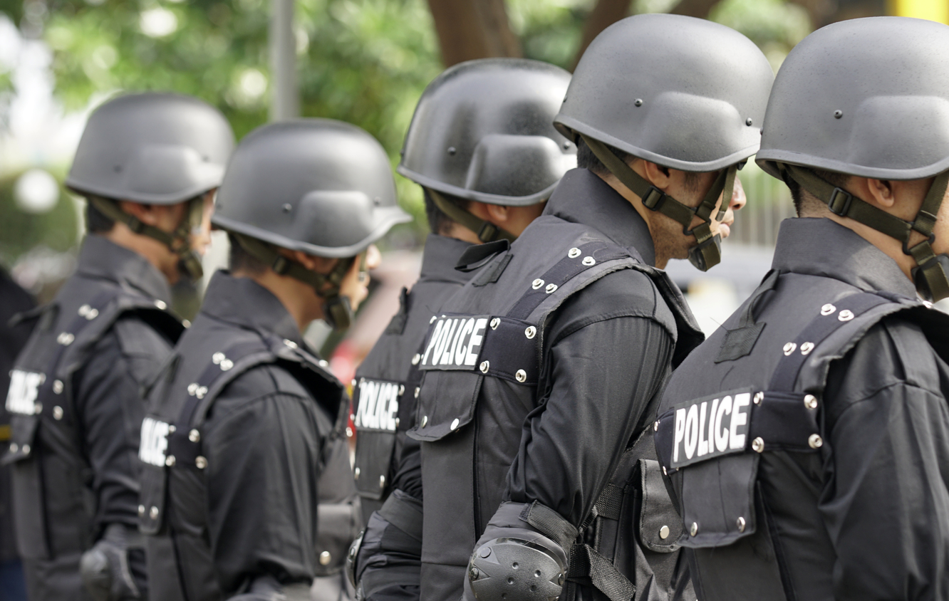 Exposición de material policial y militar en tienda de Madrid, con vitrinas de equipamiento y uniformes oficiales para profesionales de la seguridad